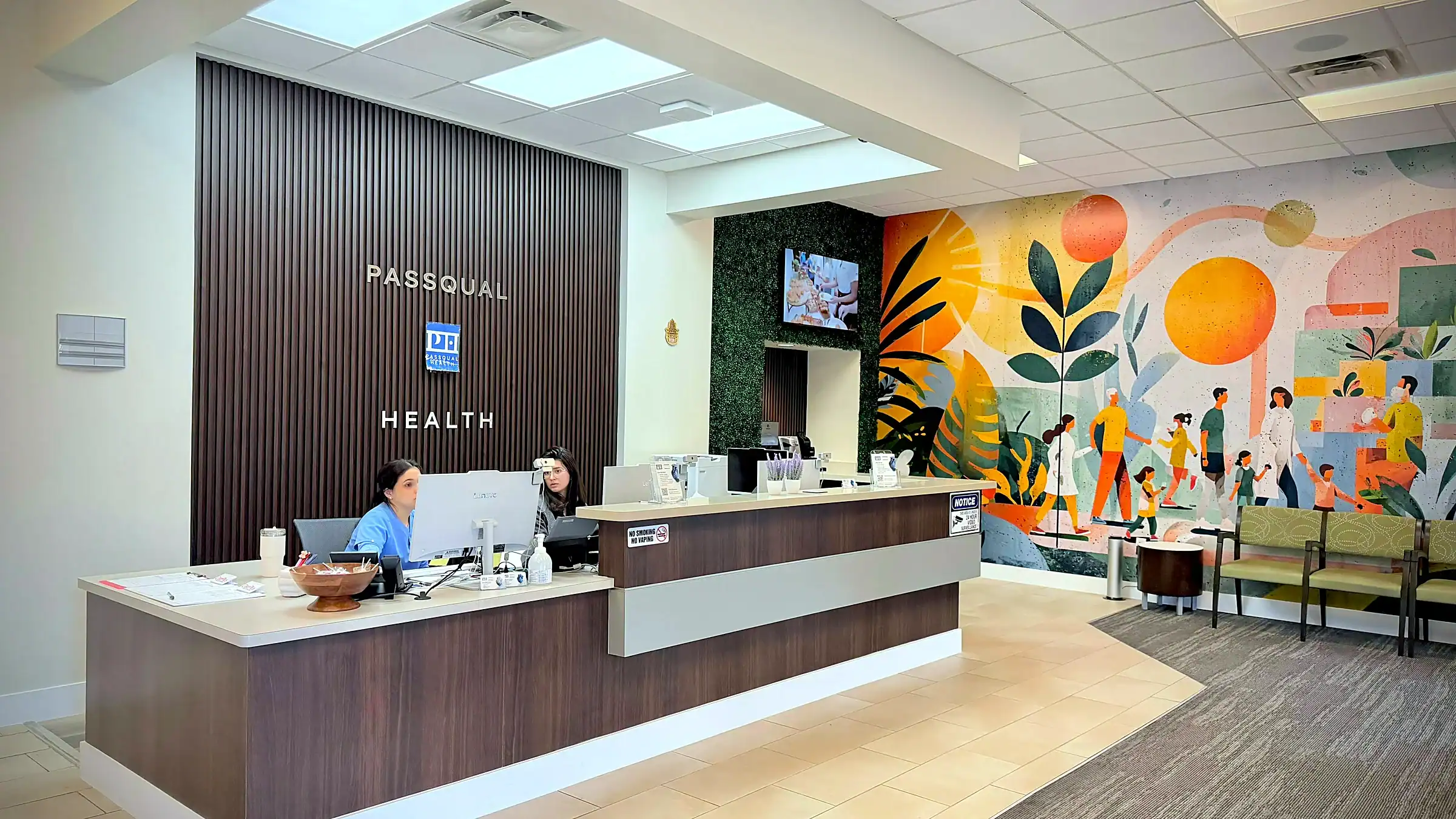 PassQual Health clinic lobby in Miami Gardens with reception desk and community mural