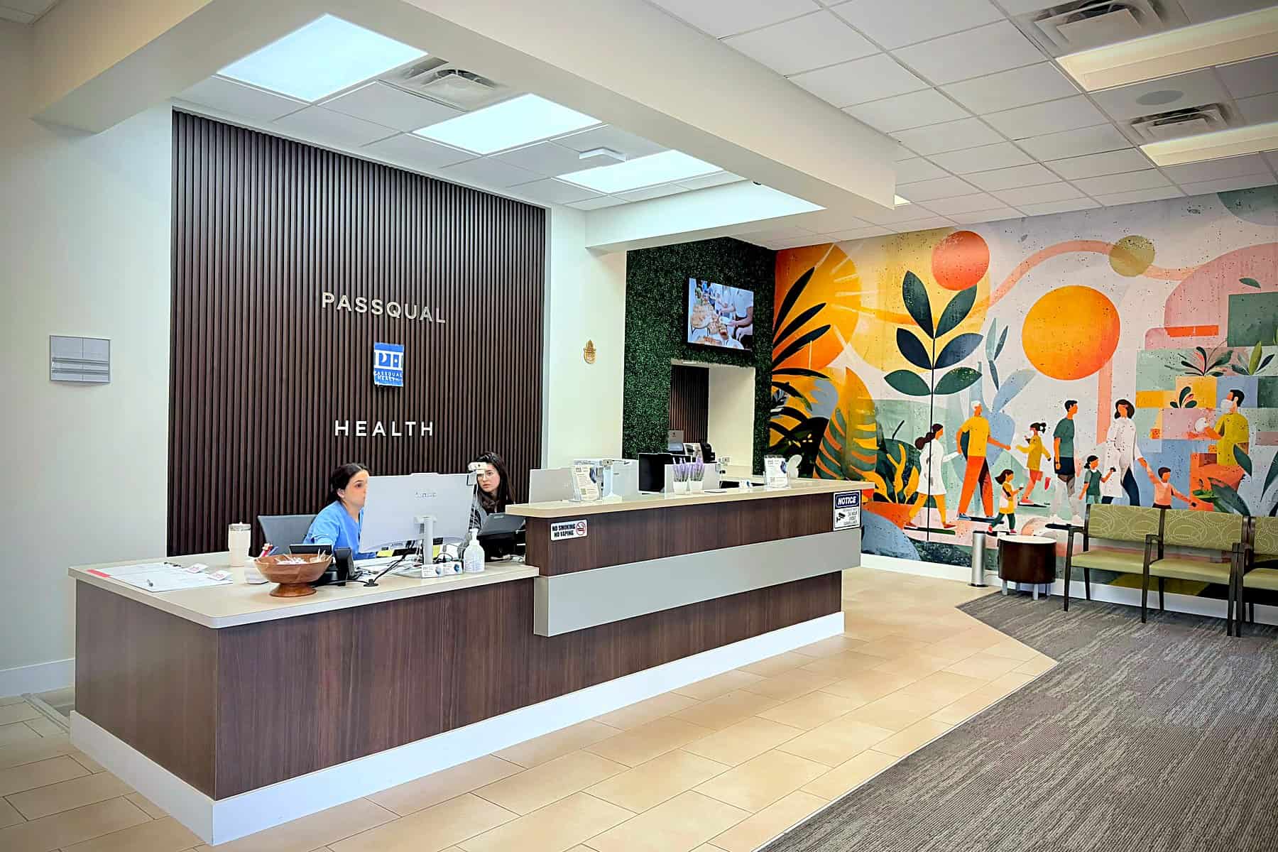 PassQual Health clinic lobby in Miami Gardens with reception desk and community mural