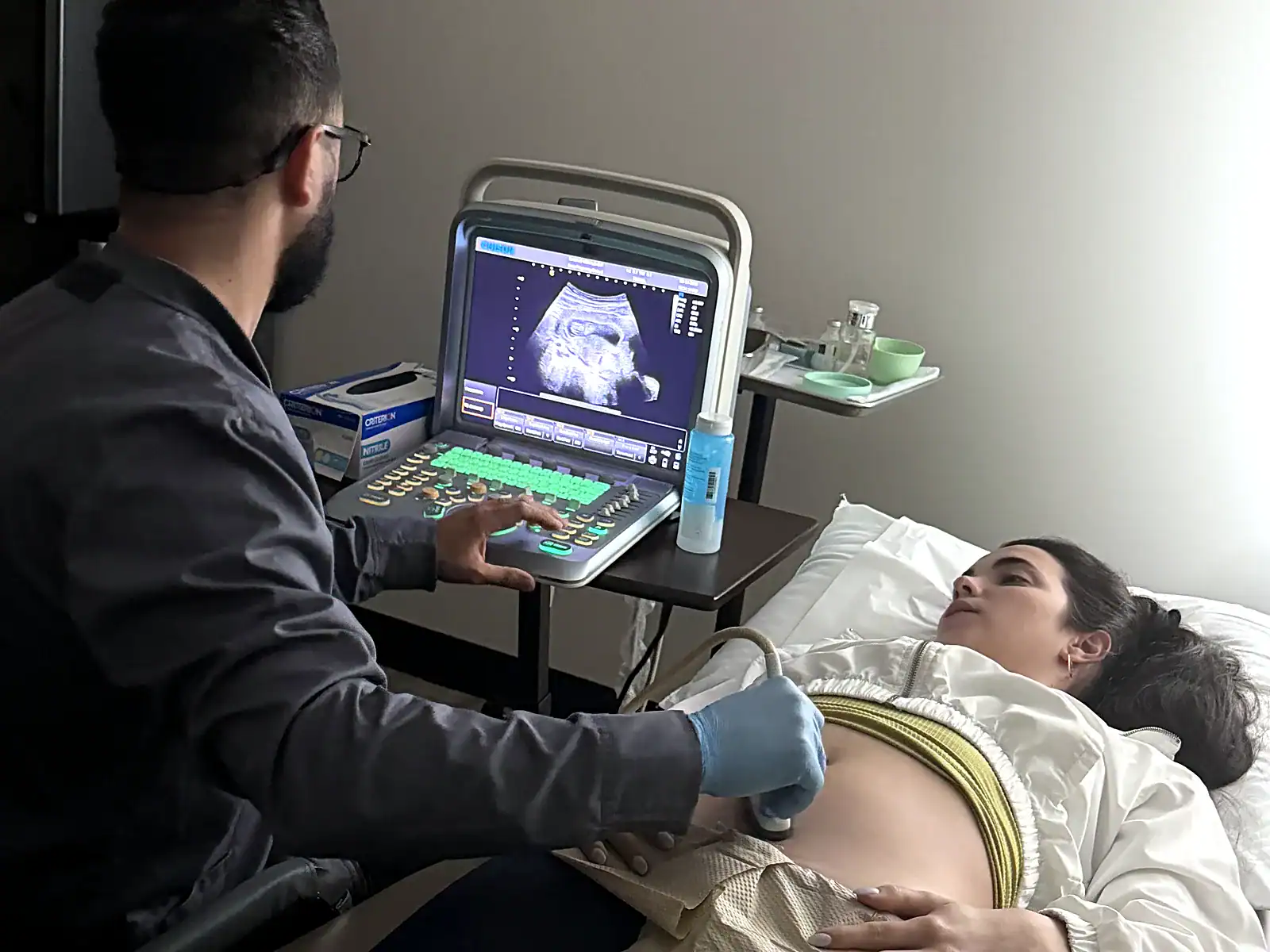 A PassQual Health sonographer performing a diagnostic ultrasound scan on a patient, with the live image on the ultrasound machine