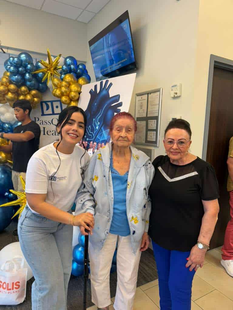 Healthcare professionals with elderly patient at PassQual Health event.